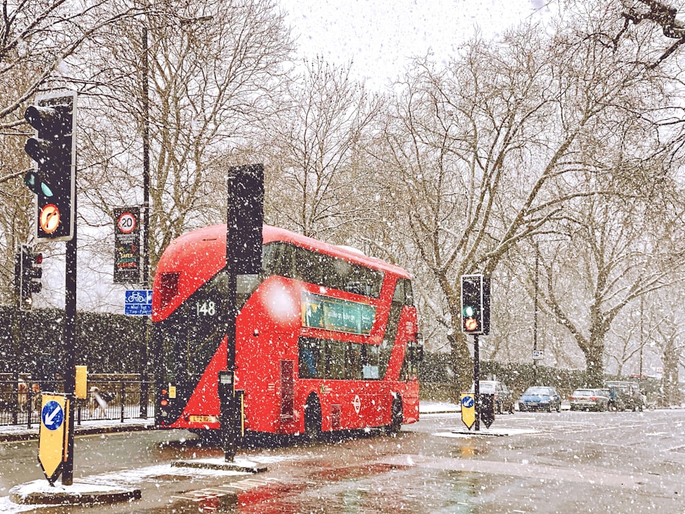 red bus on road during daytime