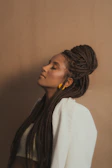 Close-up of elegant long braids styled on a black woman with a soft cream background
