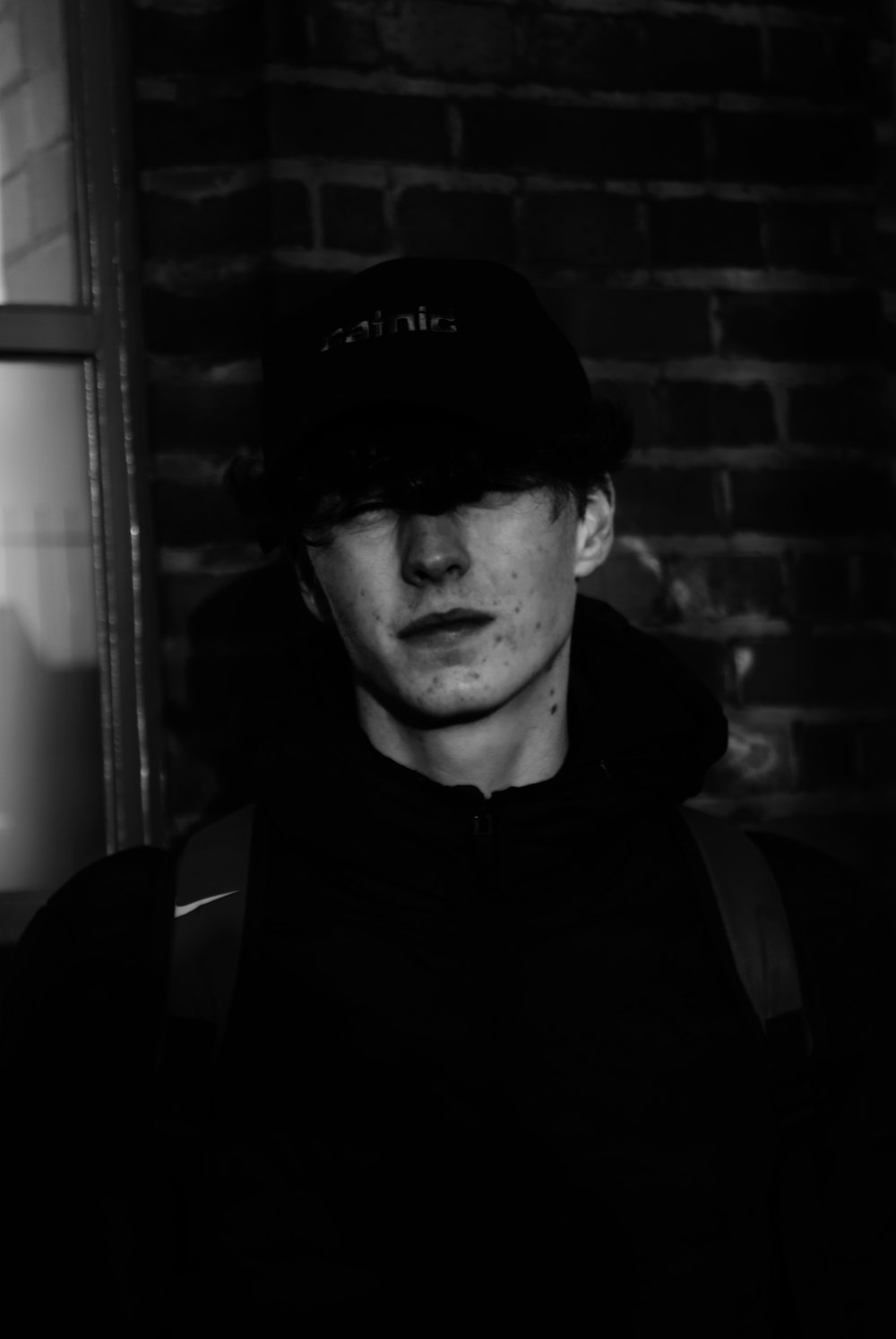 homme en noir veste zippée portant une casquette noire