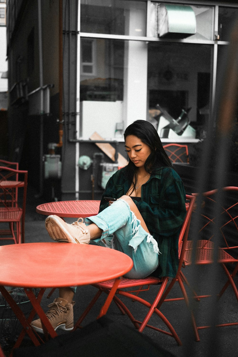 woman in blue denim jacket sitting on red chair