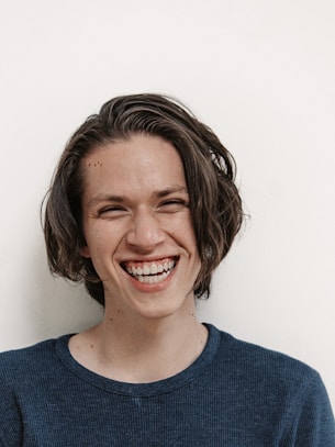 woman in blue crew neck shirt smiling