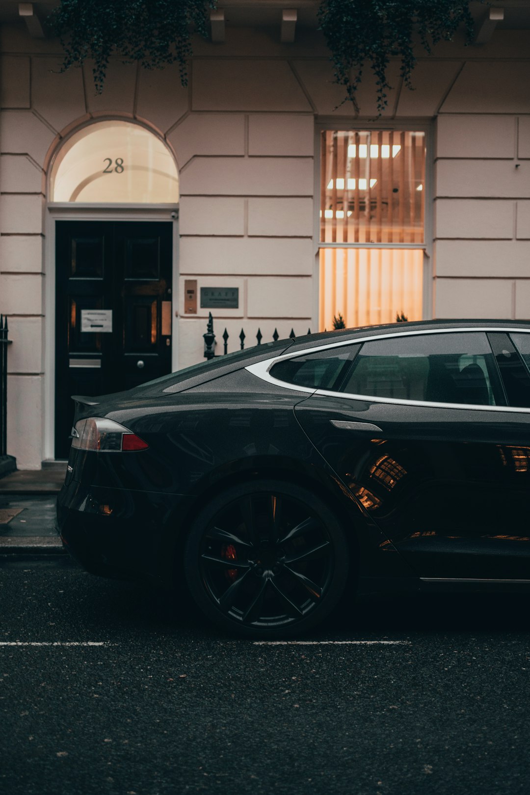 black sedan parked in front of white building