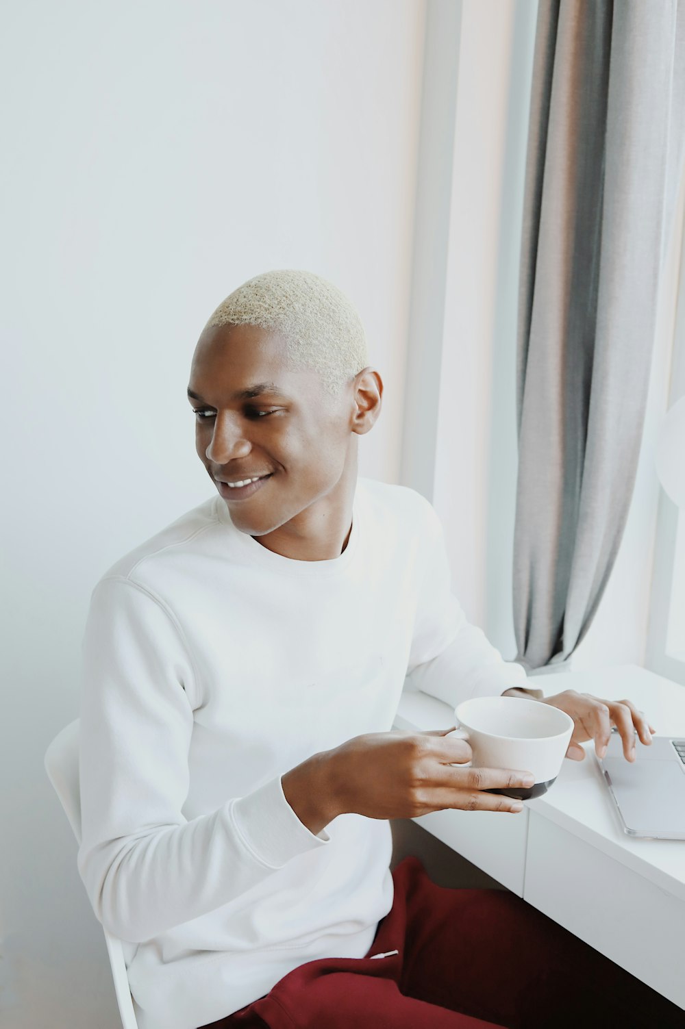 man in white long sleeve shirt holding white ceramic mug