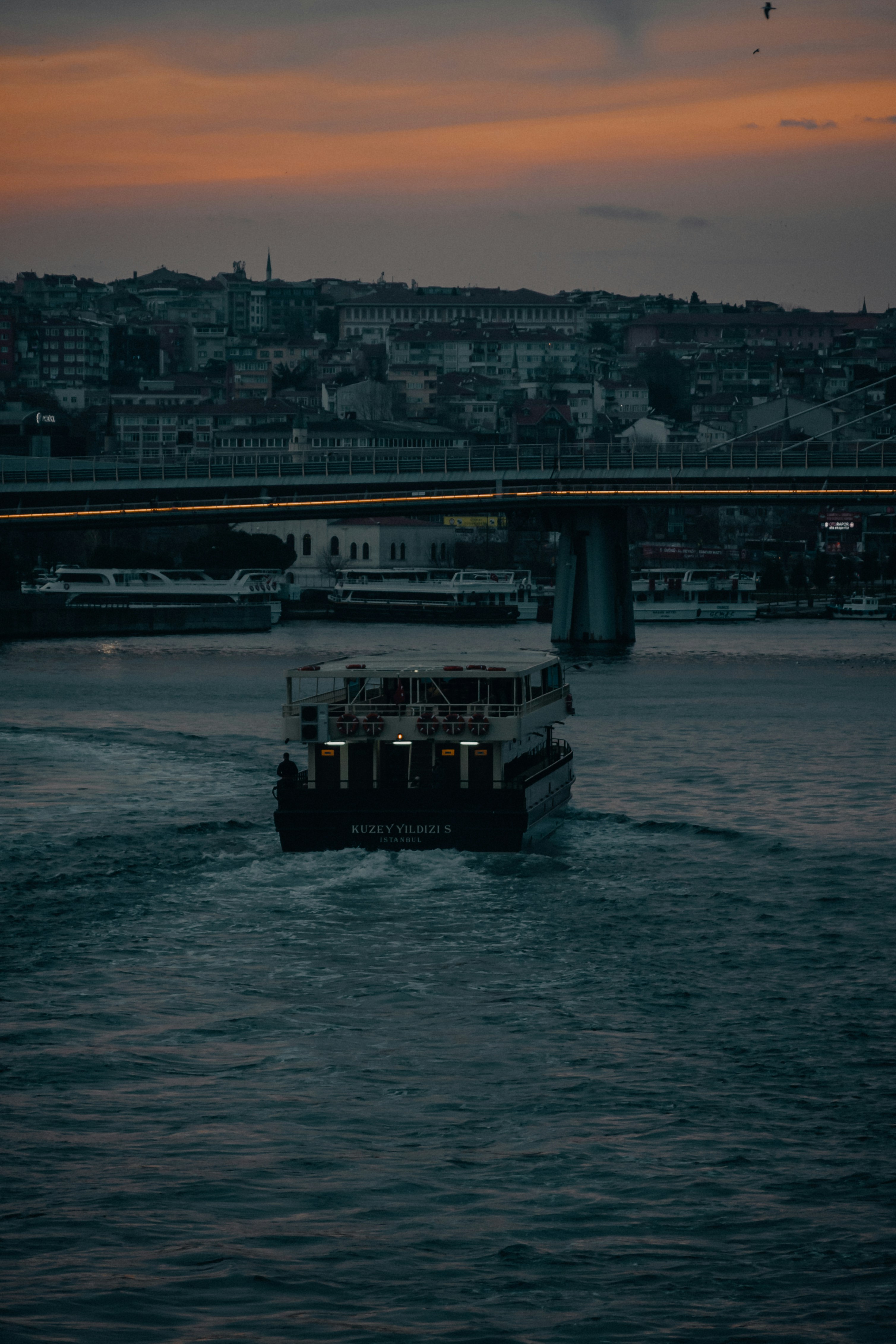 Elegant dinner setup on a boat with views of the Bosphorus Bridge