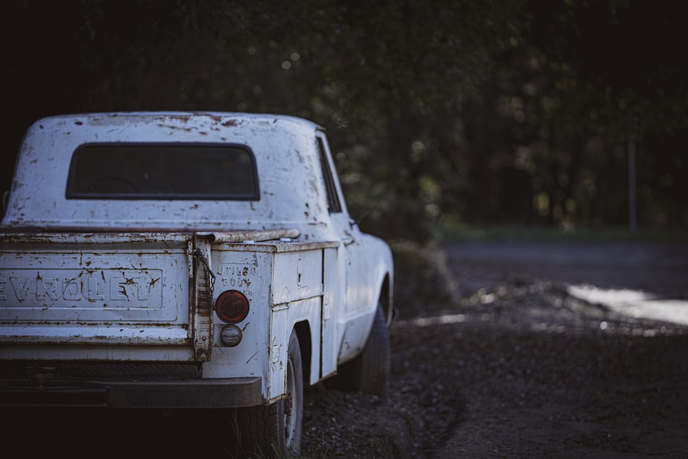 white vintage car on dirt road