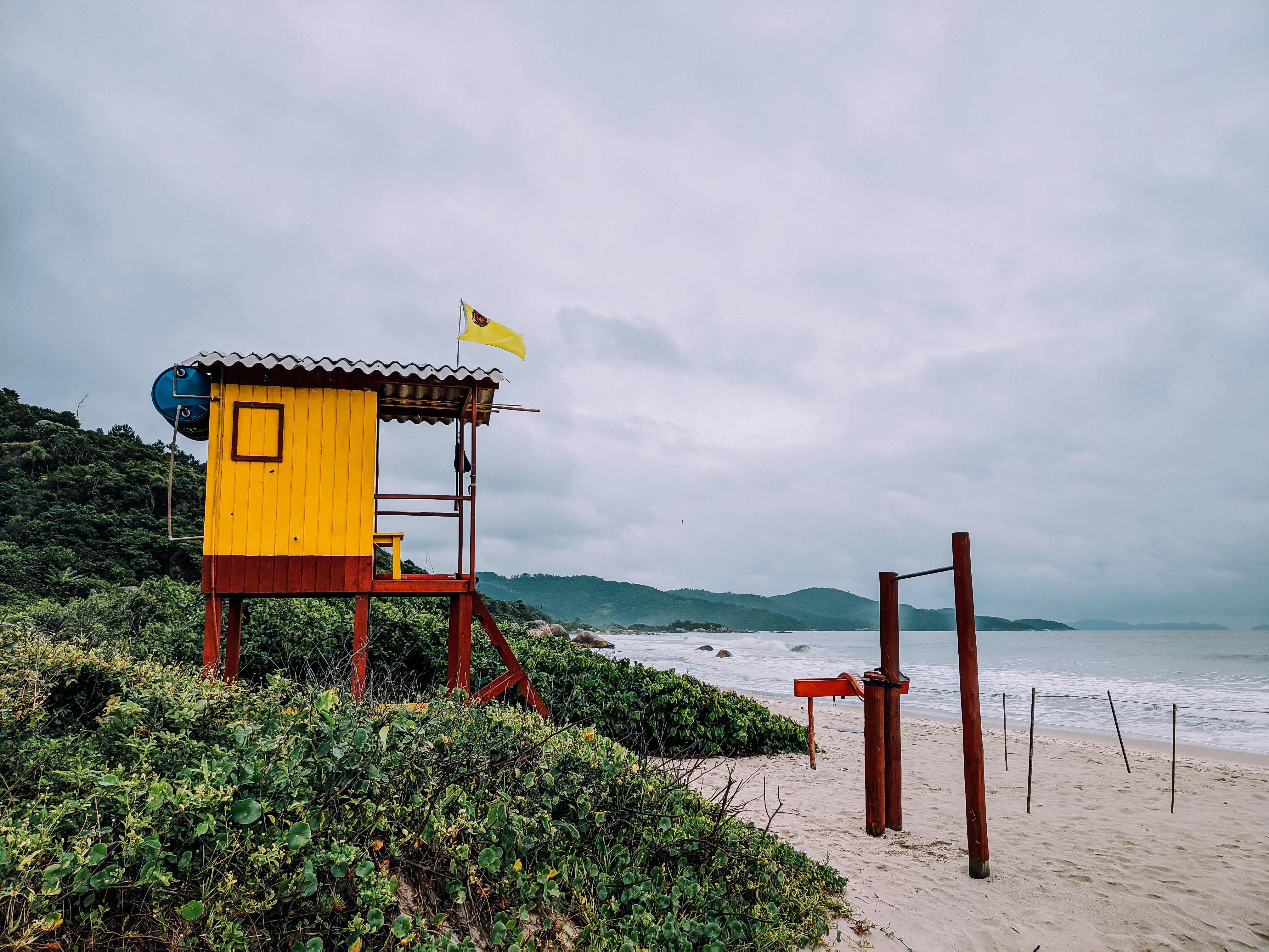 casa de salva-vidas de madeira marrom na costa durante o dia