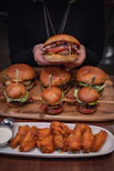 burger with lettuce and tomato on brown wooden tray