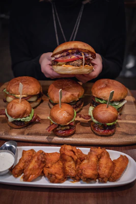 burger with lettuce and tomato on brown wooden tray