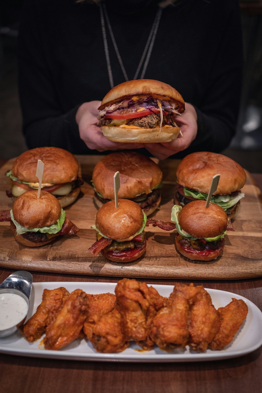 Hamburger con lattuga e pomodoro su vassoio di legno marrone