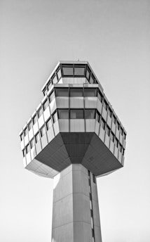 A sleek, eco-conscious tower featuring brutalist and neo-classical elements under a clear sky.