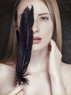 woman with black feather on her face