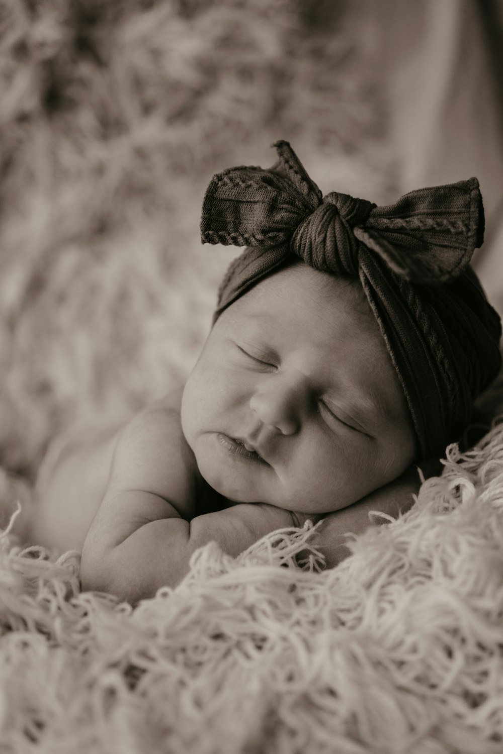 grayscale photo of baby wearing black and white polka dot headband