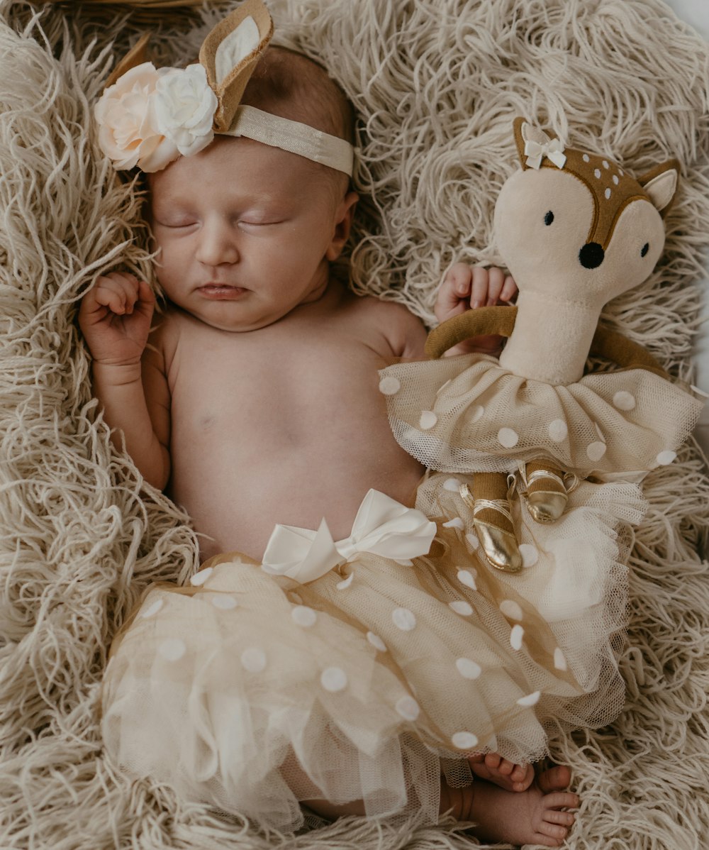 baby lying on white fur textile