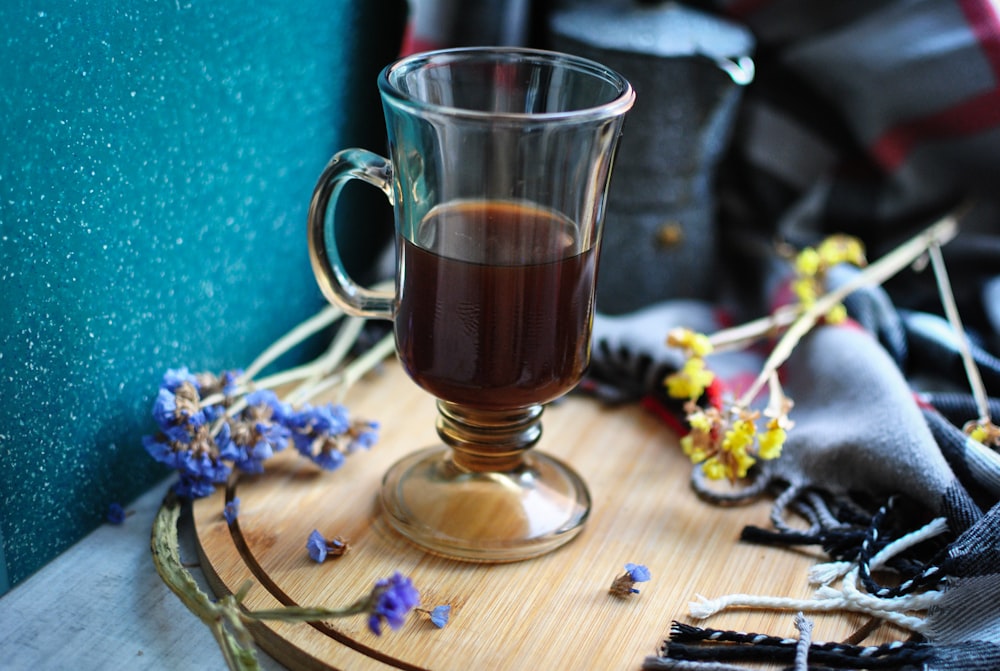 clear glass mug with brown liquid