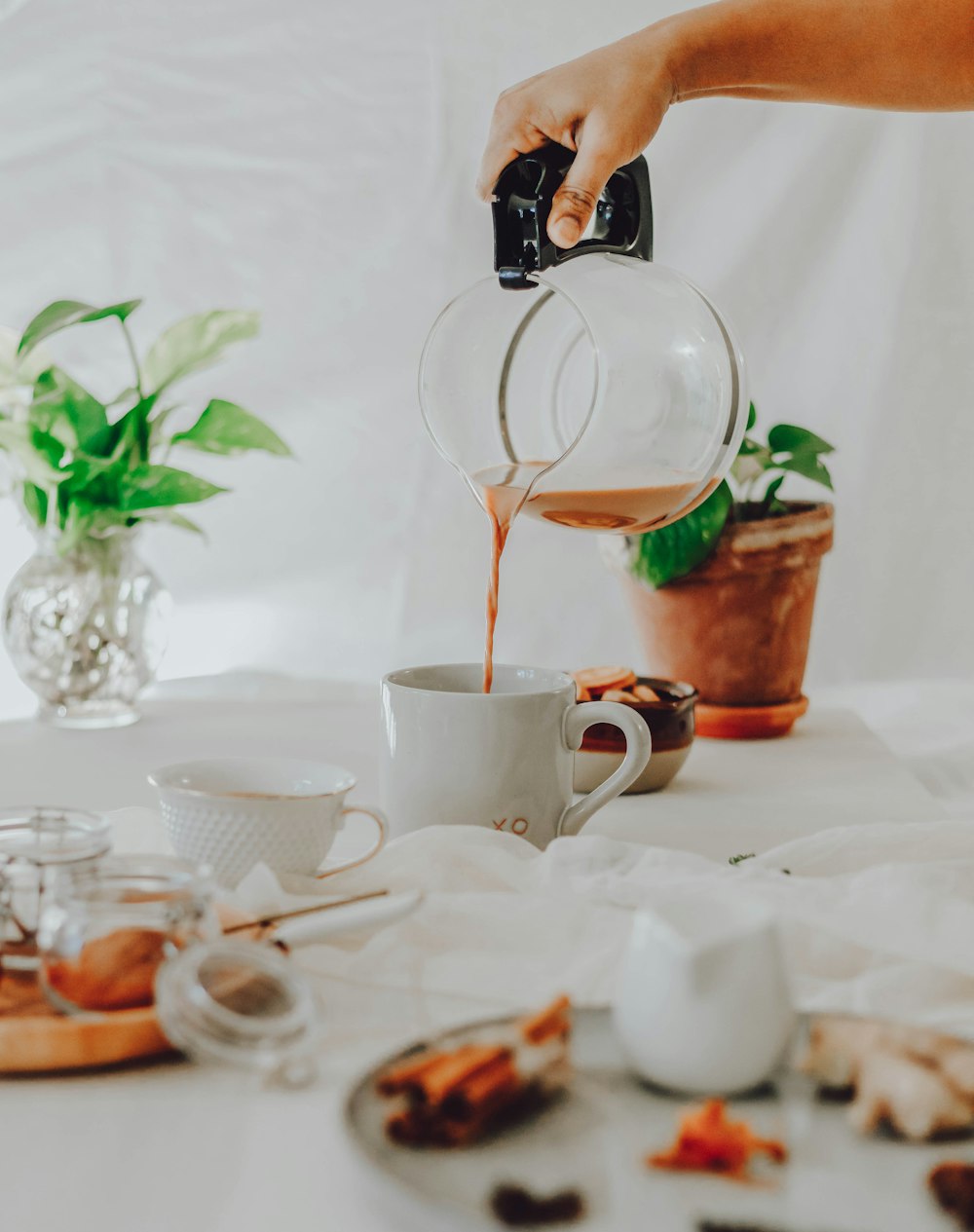 person pouring water on white ceramic mug