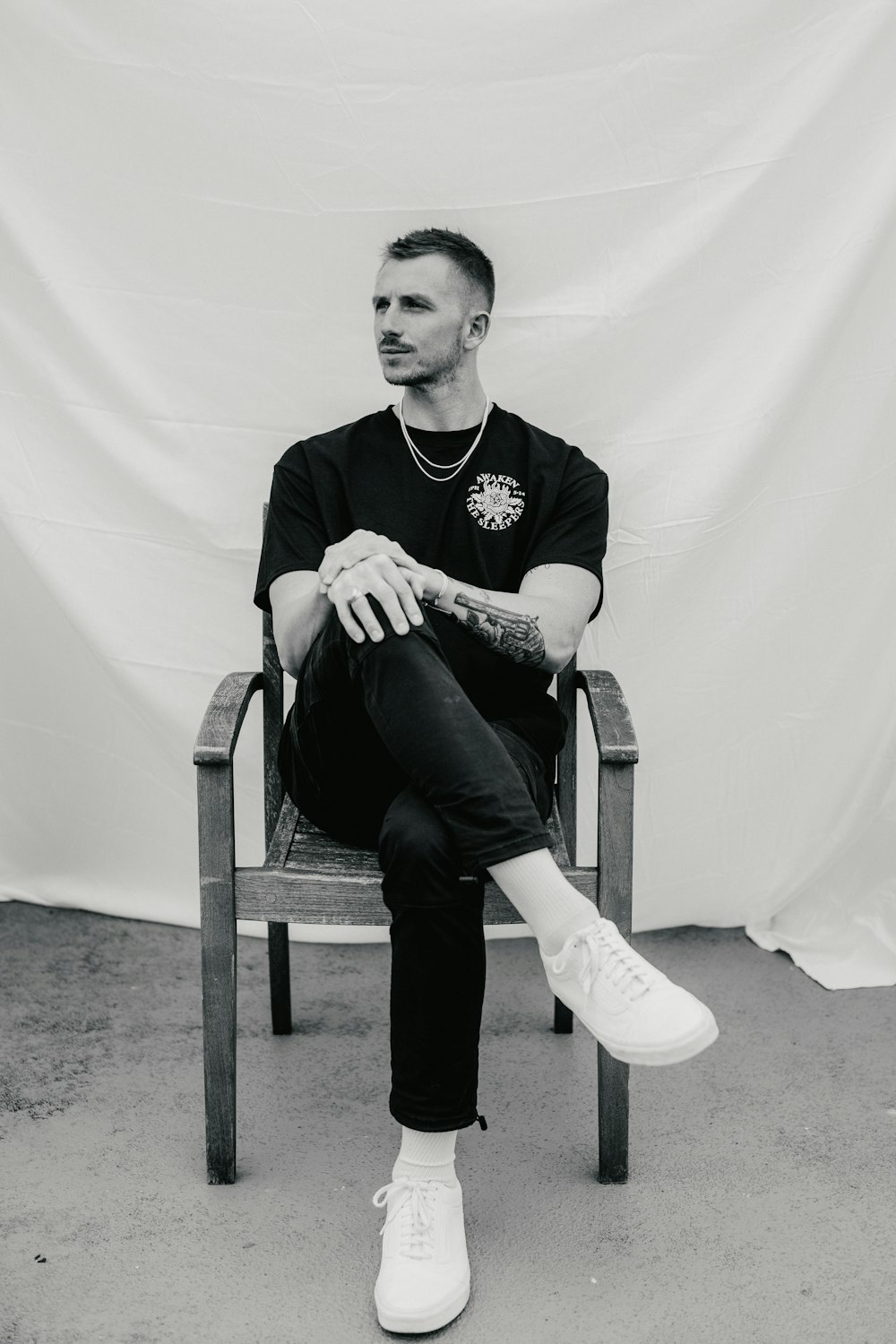 man in black long sleeve shirt sitting on white armchair