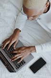 person in white long sleeve shirt using macbook pro