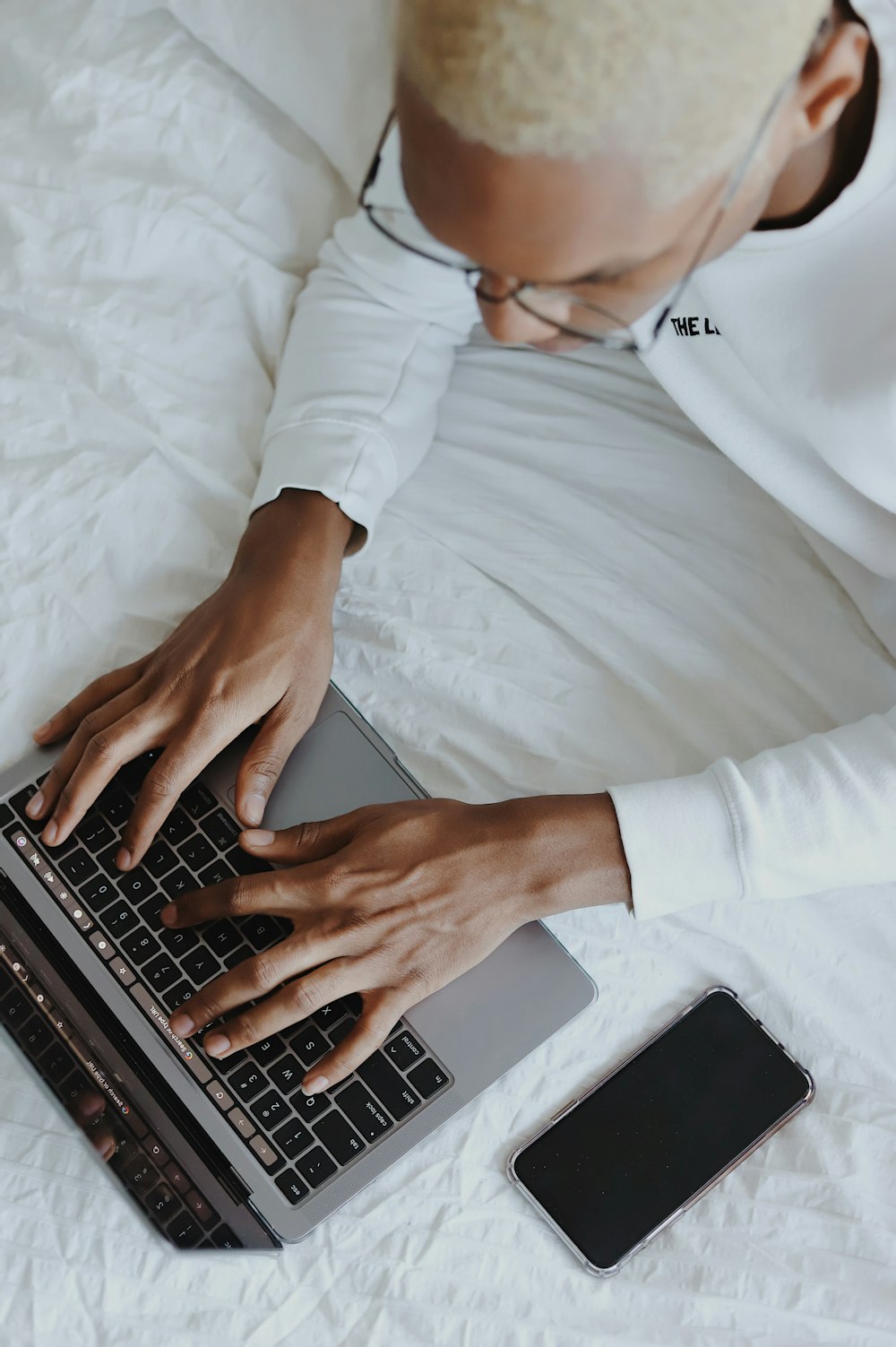 person in white long sleeve shirt using macbook pro