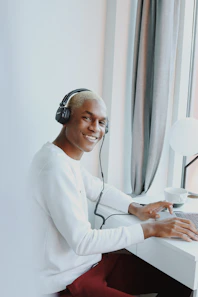 A friendly person at a desk with a laptop, ready to assist with career guidance questions.