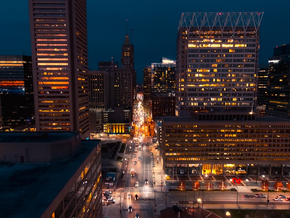 people walking on street near high rise buildings during night time