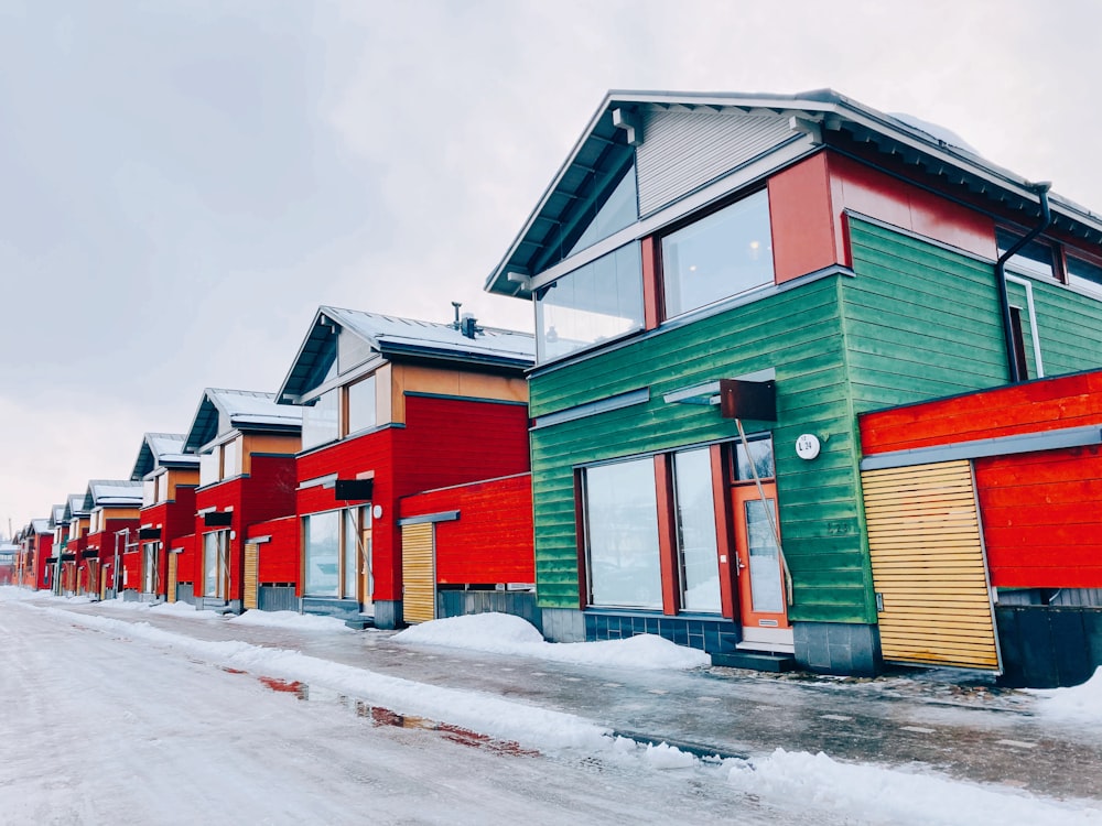 Casas rojas, verdes y amarillas en suelo cubierto de nieve