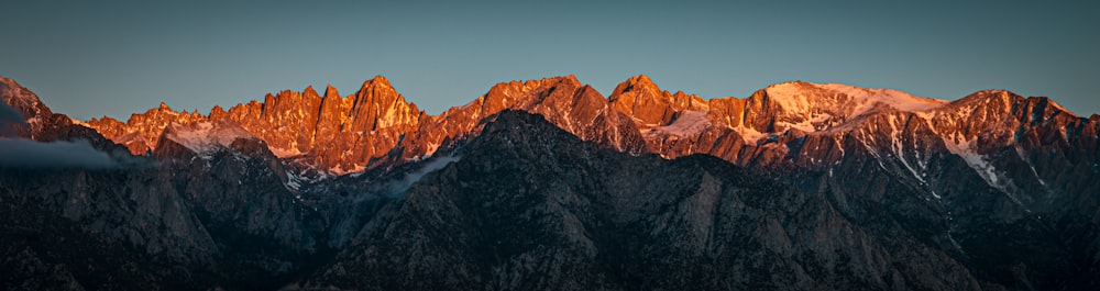 Montaña marrón y negra bajo el cielo azul durante el día