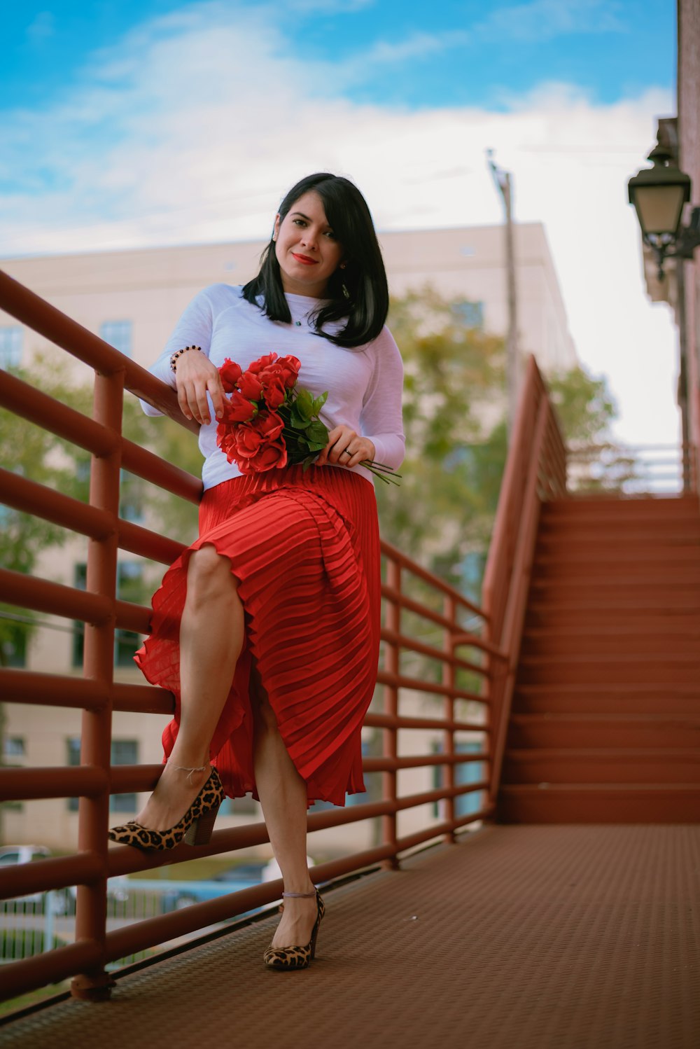 woman in red and white dress holding bouquet of flowers