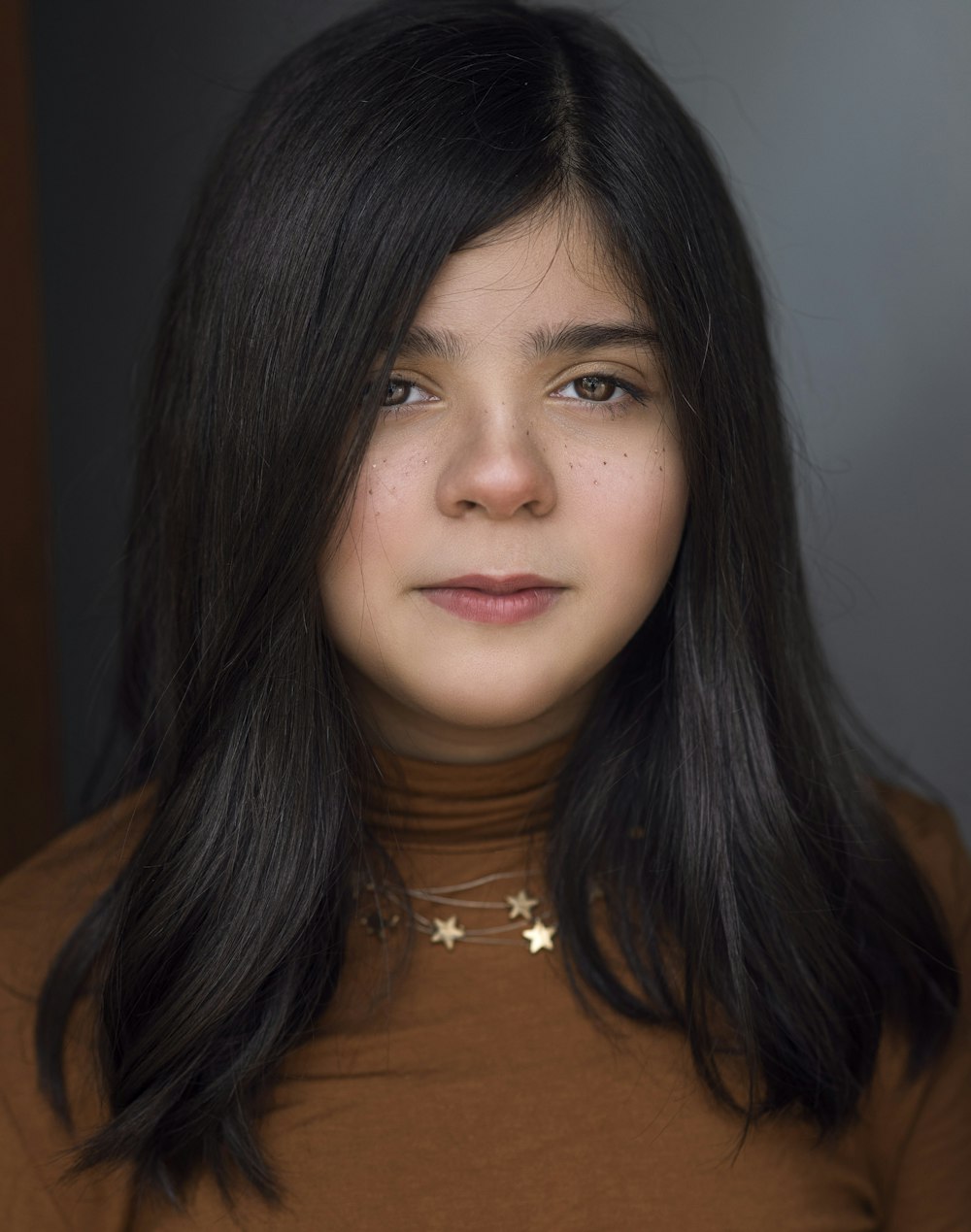 woman in brown shirt wearing silver necklace