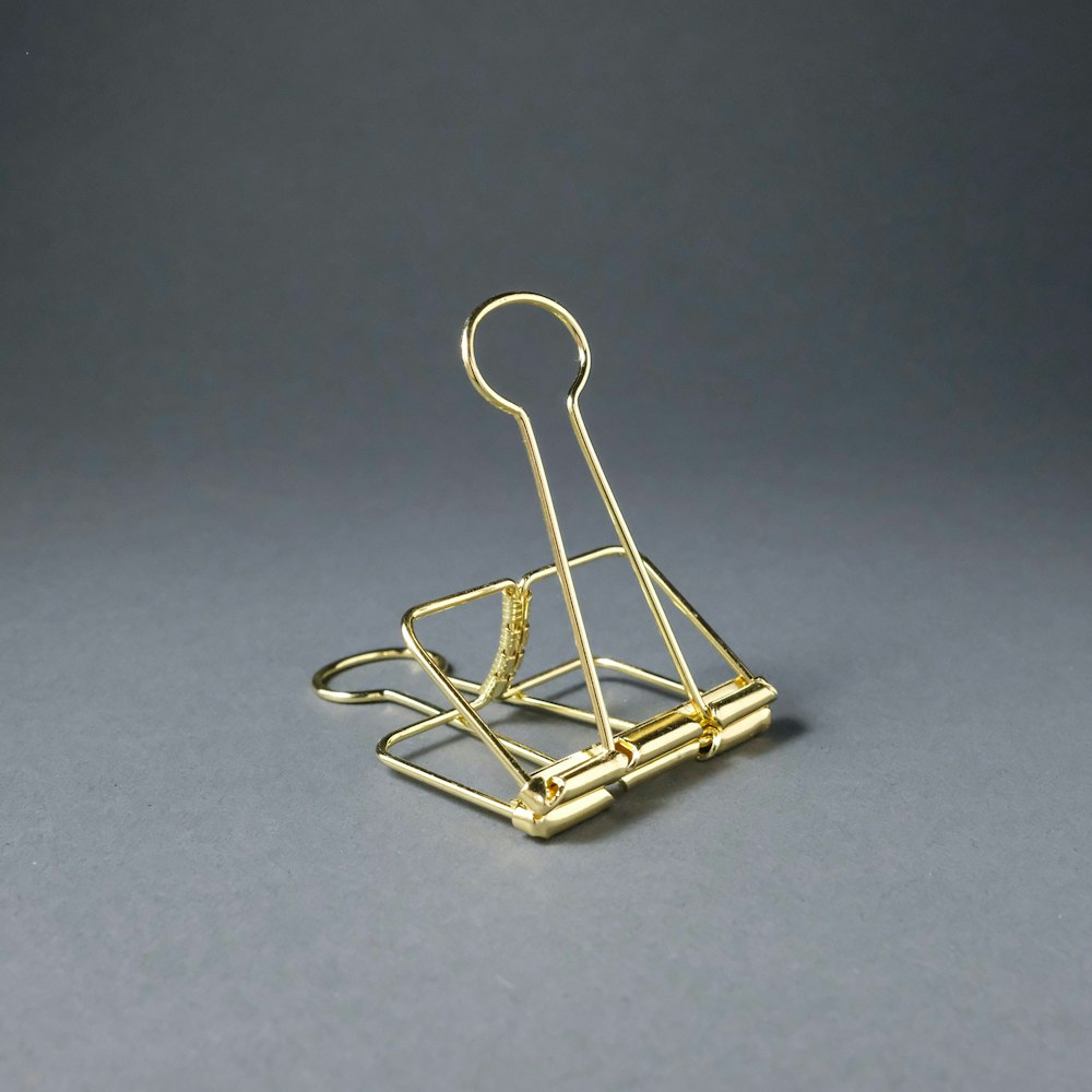 gold paper clip on gray surface