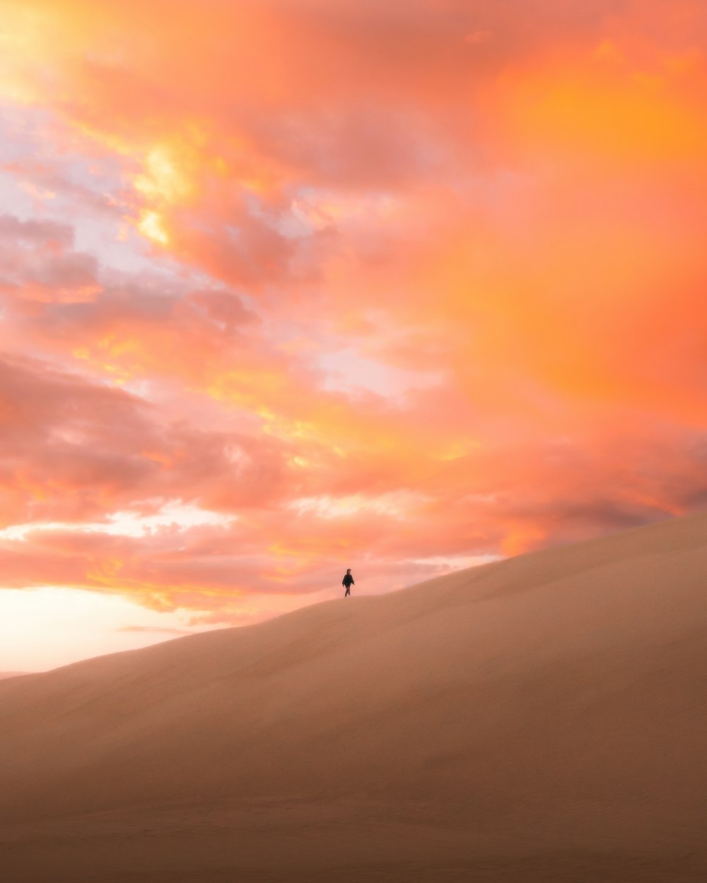 person standing on top of mountain during sunset