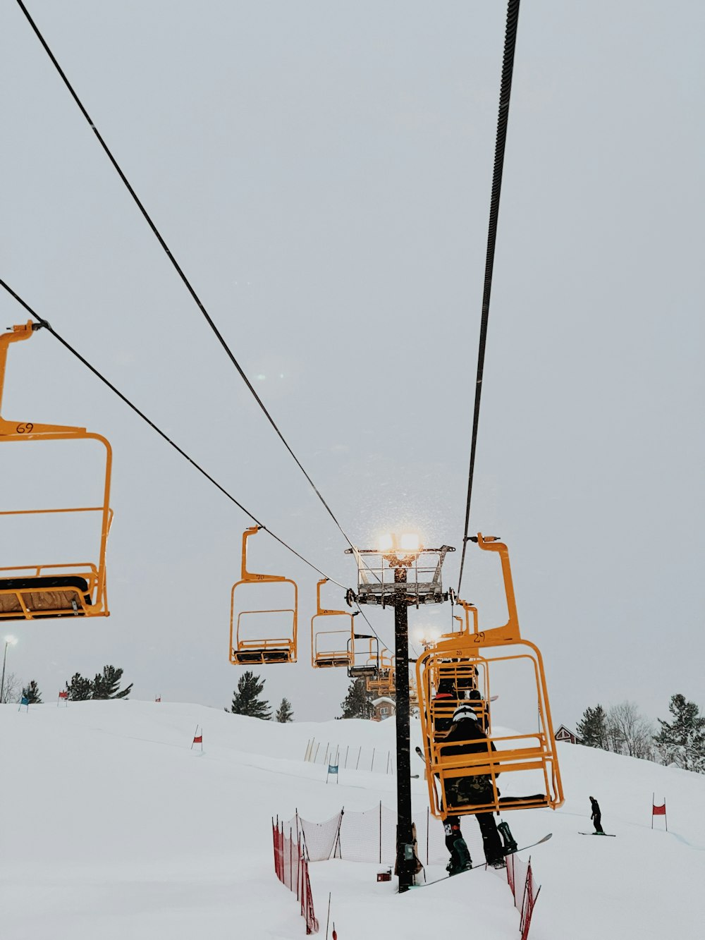 a ski lift with two people on it in the snow