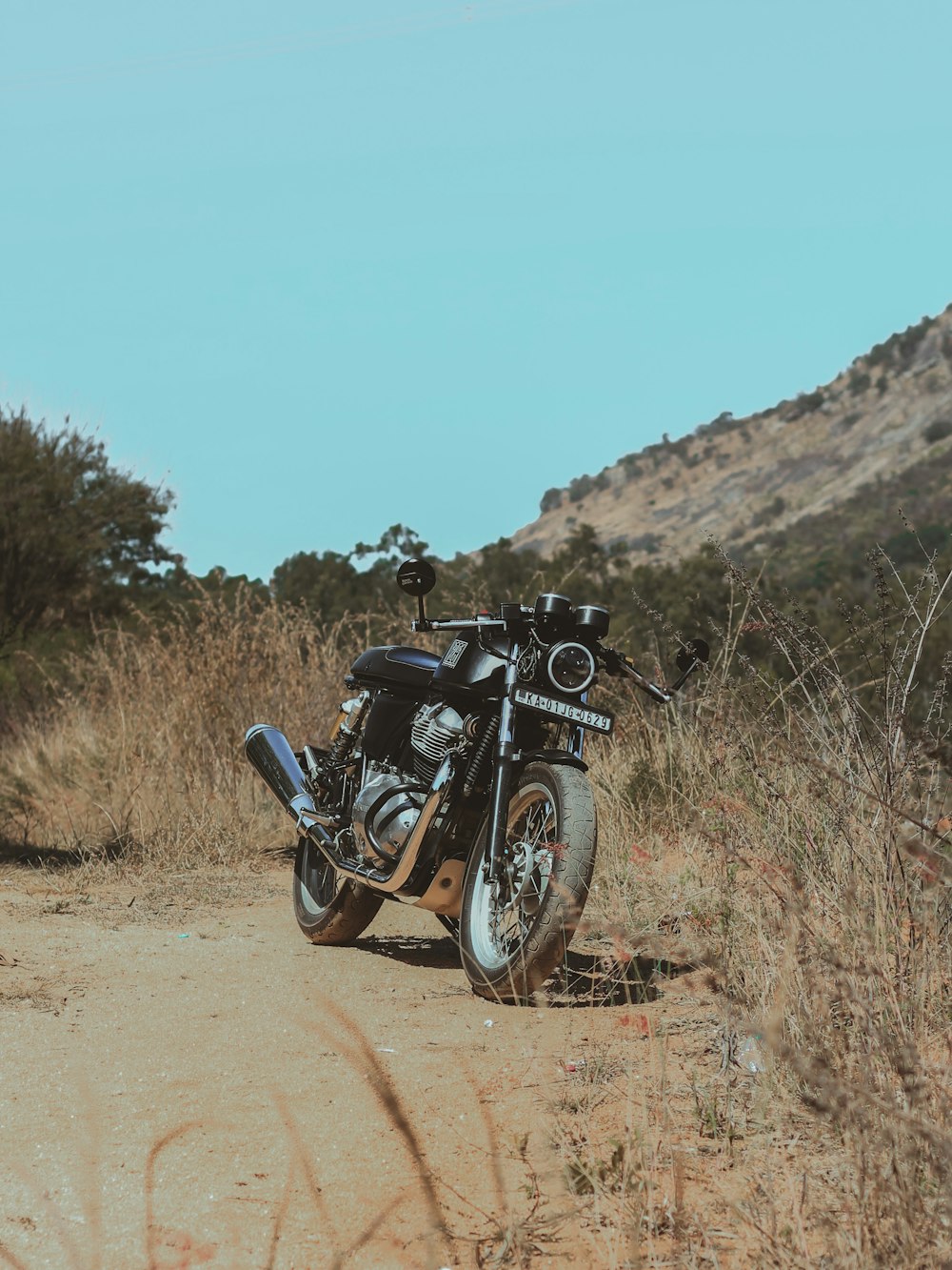 black motorcycle on brown dirt road during daytime