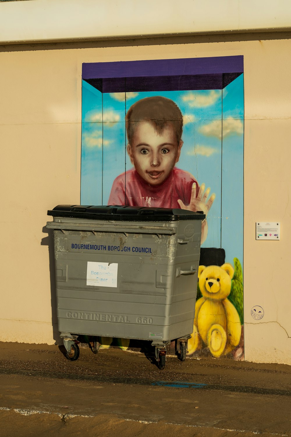 boy in blue and white shirt standing beside blue and white plastic storage box