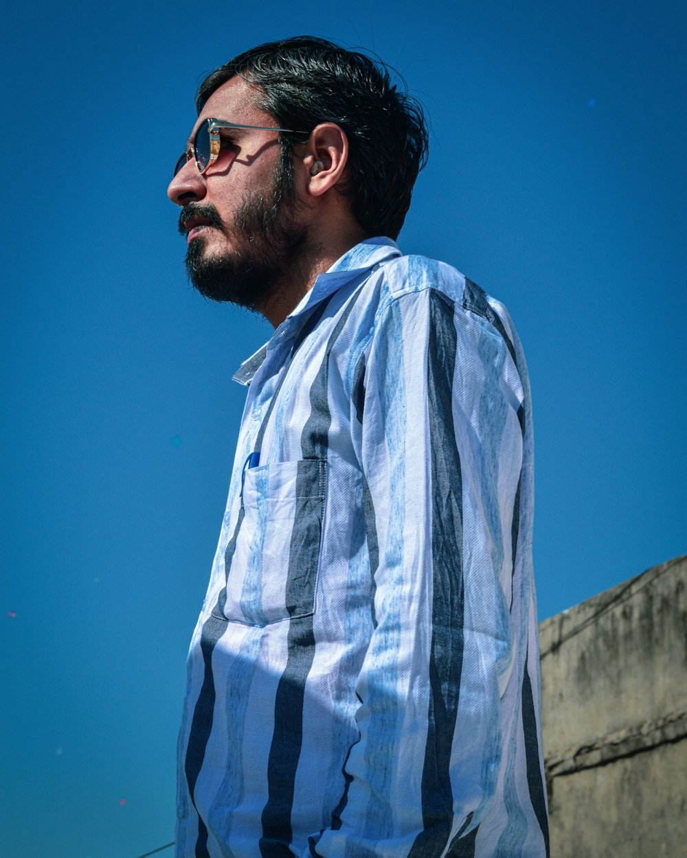 man in blue and white plaid dress shirt wearing black framed eyeglasses