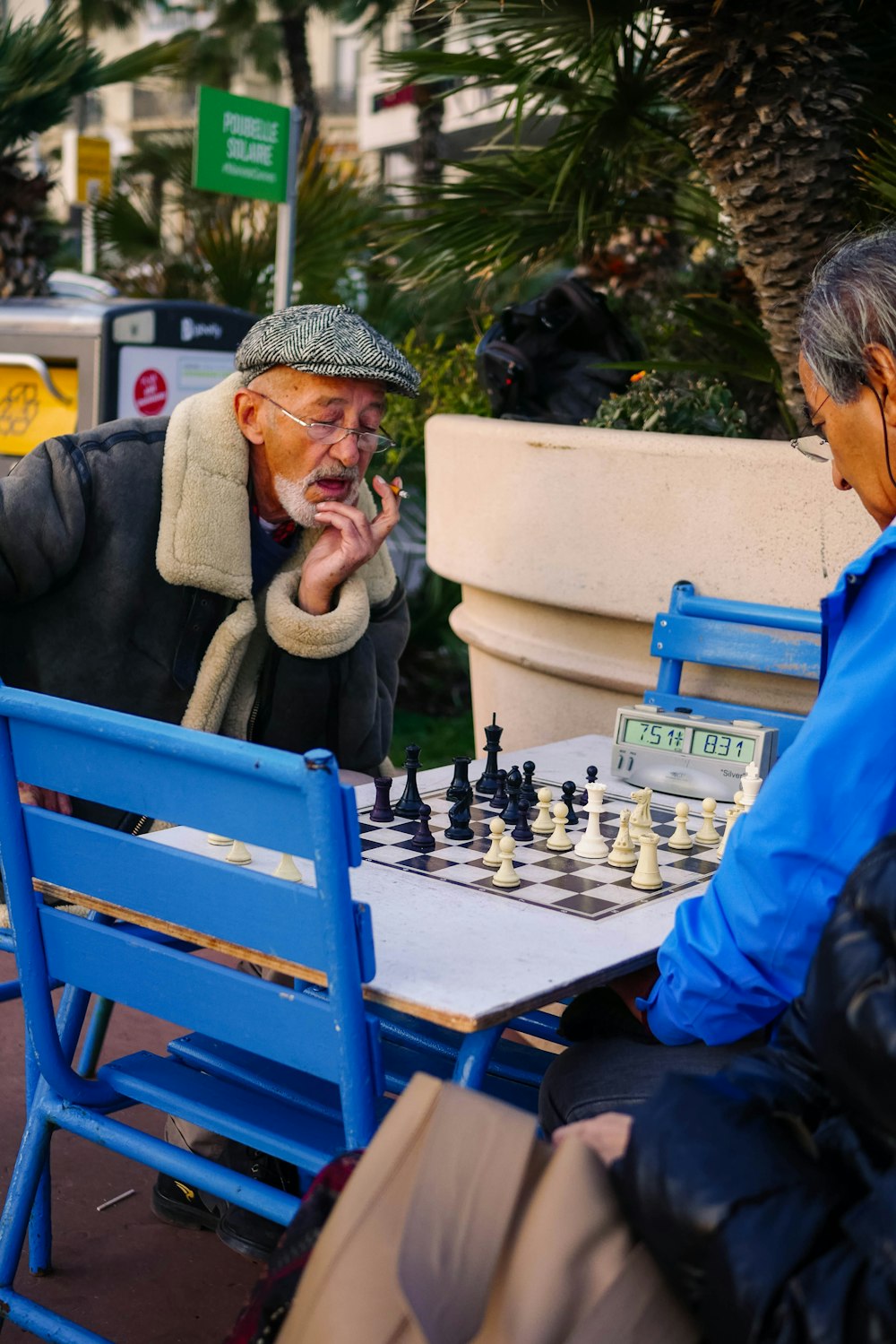 man in blue jacket sitting on blue chair