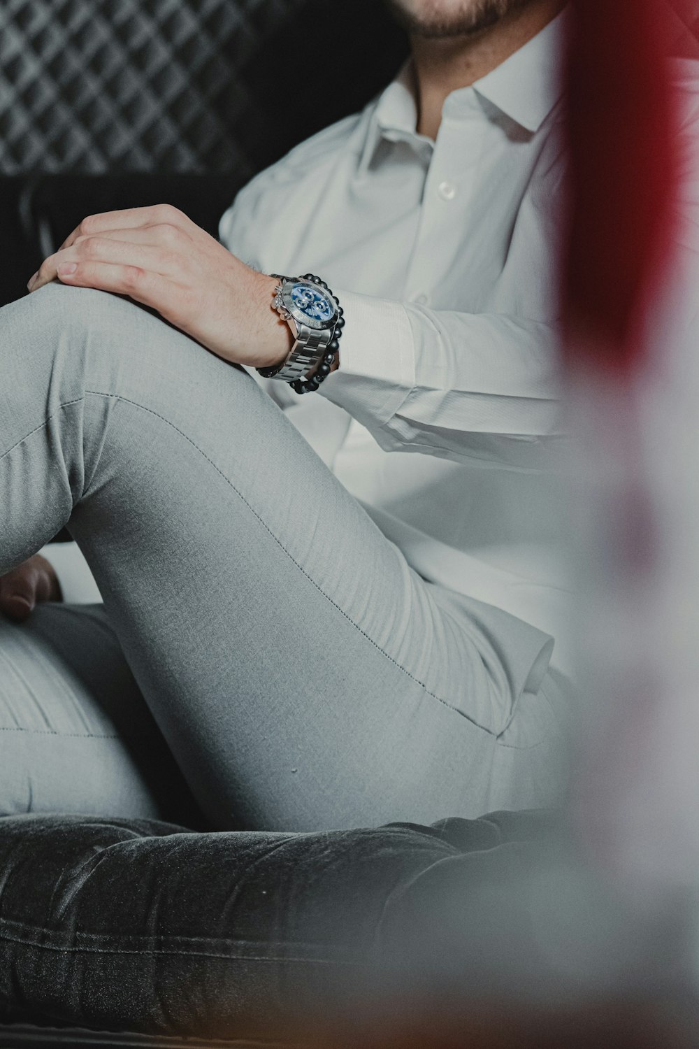 person in white dress shirt and gray pants sitting on white couch