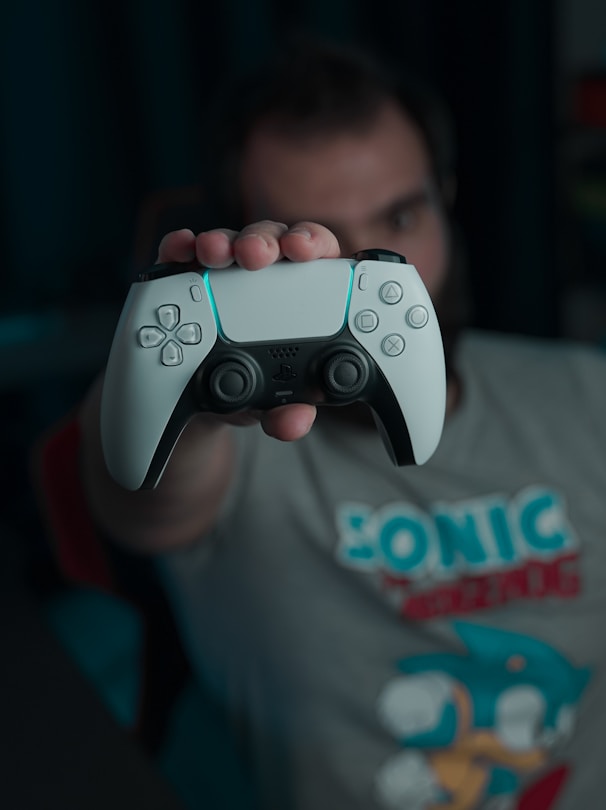 boy in gray and red crew neck t-shirt holding gray game controller