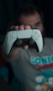 boy in gray and red crew neck t-shirt holding gray game controller