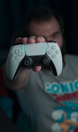 boy in gray and red crew neck t-shirt holding gray game controller