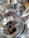 Stacks of stainless steel frying pans with labels are neatly displayed, highlighting their shiny surfaces and sturdy handles.