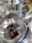 Stacks of stainless steel frying pans with labels are neatly displayed, highlighting their shiny surfaces and sturdy handles.