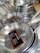 Stacks of stainless steel frying pans with labels are neatly displayed, highlighting their shiny surfaces and sturdy handles.