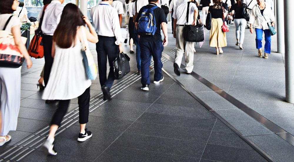 people walking on gray pavement