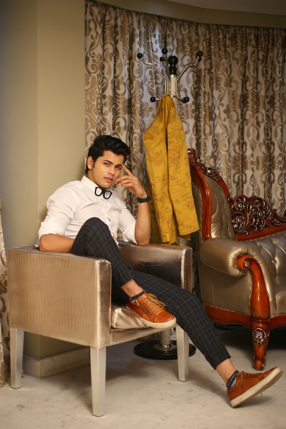 woman in white shirt and black pants sitting on brown leather armchair