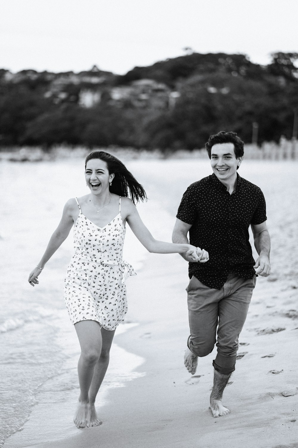 man and woman walking on beach during daytime