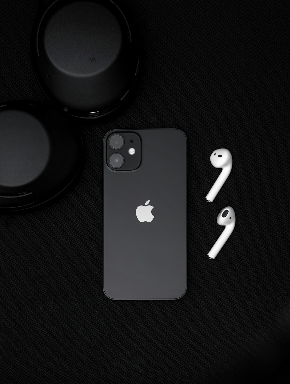 iPhone 7 noir à côté d’un casque noir