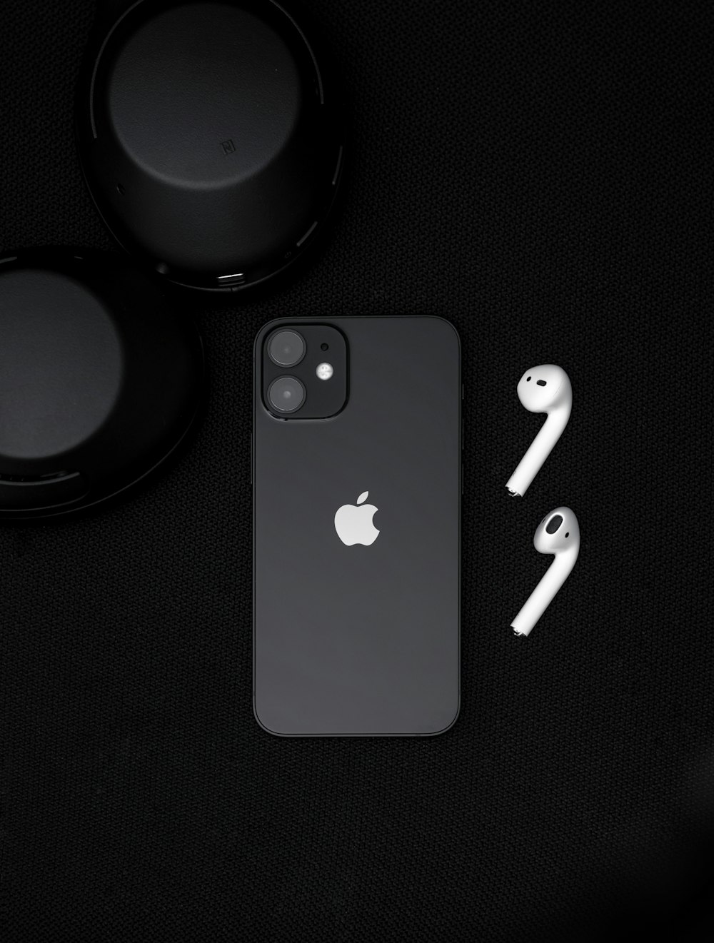 black iphone 7 beside black headphones