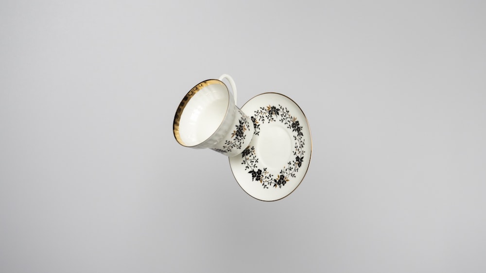 white and gold floral ceramic teacup