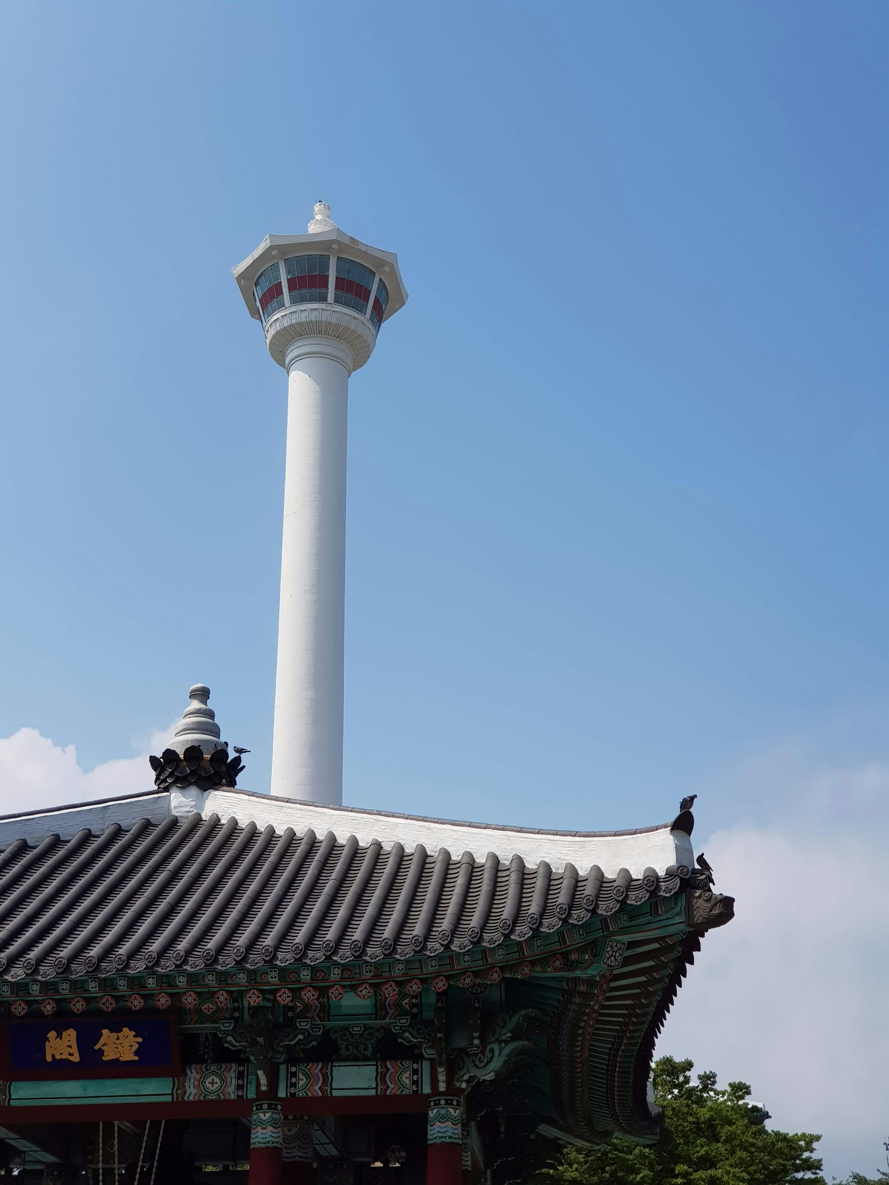 昼間の青空に浮かぶ白と茶色のコンクリート塔