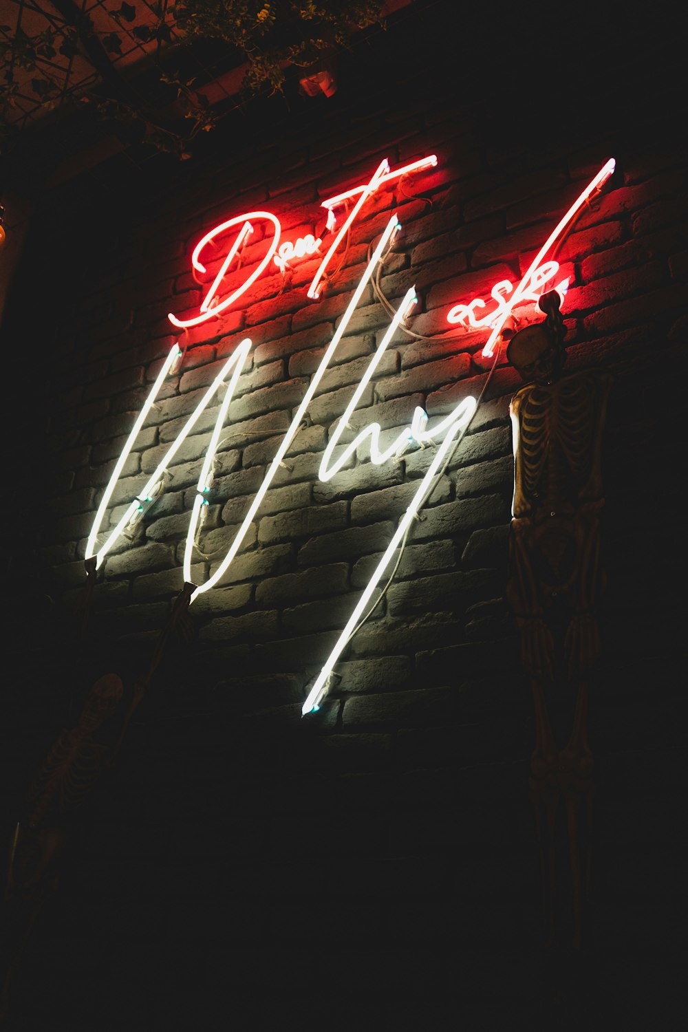 a brick wall with a neon sign on it